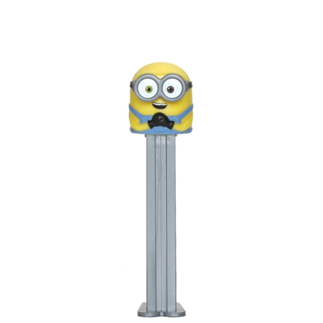 A Minions-themed Pez dispenser featuring a yellow character head with goggles and a blue collar on a silver metal body, isolated on a white background.