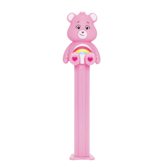 Pink Cheer Bear PEZ dispenser with a rainbow and heart belly badge, heart-shaped nose, and pink candy stem.