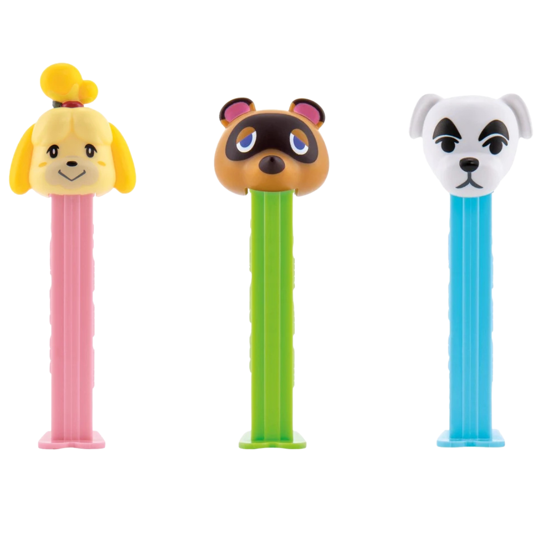 Three Animal Crossing PEZ dispensers featuring Isabelle with yellow ears and a topknot on a pink stem, Tom Nook the brown raccoon on a green stem, and K.K. Slider the white dog with black markings on a blue stem.