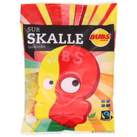 BUBS Sour Skulls, 90g bag in red and yellow packaging with a skull-shaped graphic and sour sugar-coated candy pieces in yellow, green, and orange shown through the front window.