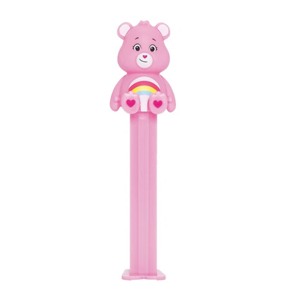 Pink Cheer Bear PEZ dispenser with a rainbow and heart belly badge, heart-shaped nose, and pink candy stem.