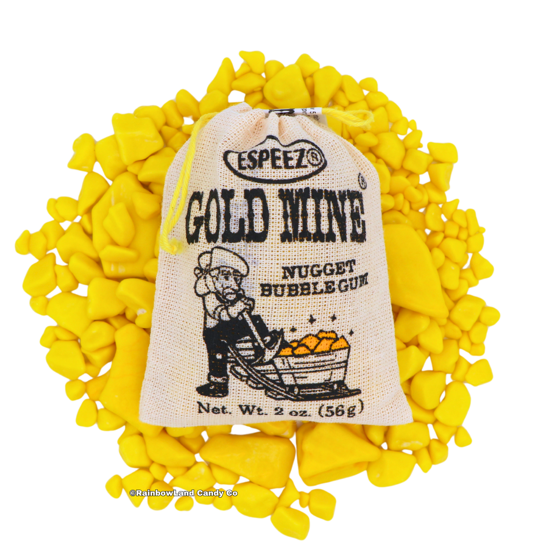 A 2 oz Gold Mine Nugget Bubble Gum burlap pouch with a prospector illustration resting on top of a scattered pile of yellow gold nugget-shaped banana bubble gum pieces.