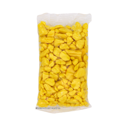 Yellow gold nugget-shaped banana bubble gum pieces packed inside a clear plastic bag, shown standing upright against a white background.