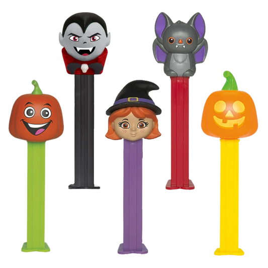 Five PEZ Halloween dispensers lined up together — a smiling green pumpkin, a purple-winged gray bat, a red-haired witch in a black hat, a black-caped vampire, and an orange jack-o'-lantern.