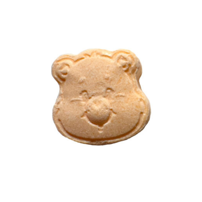 Close-up of a single orange sour candy piece shaped like a Care Bear face, featuring embossed ears, eyes, and a smiling mouth, part of the Care Bears Scare Bears Halloween Candy Tin.