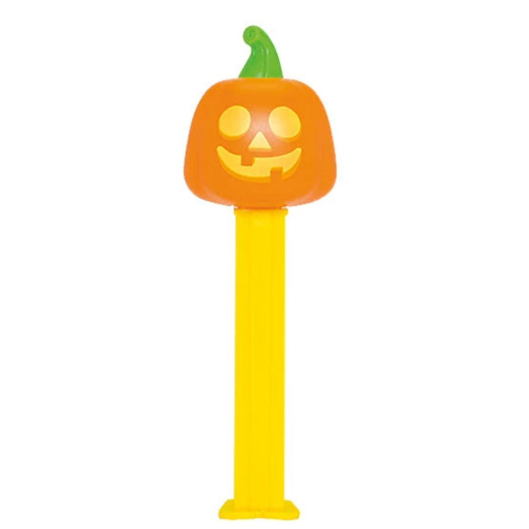 Halloween PEZ dispenser featuring a glowing jack-o-lantern face with a green stem, yellow dispenser, sold by RainbowLand Candy Co.