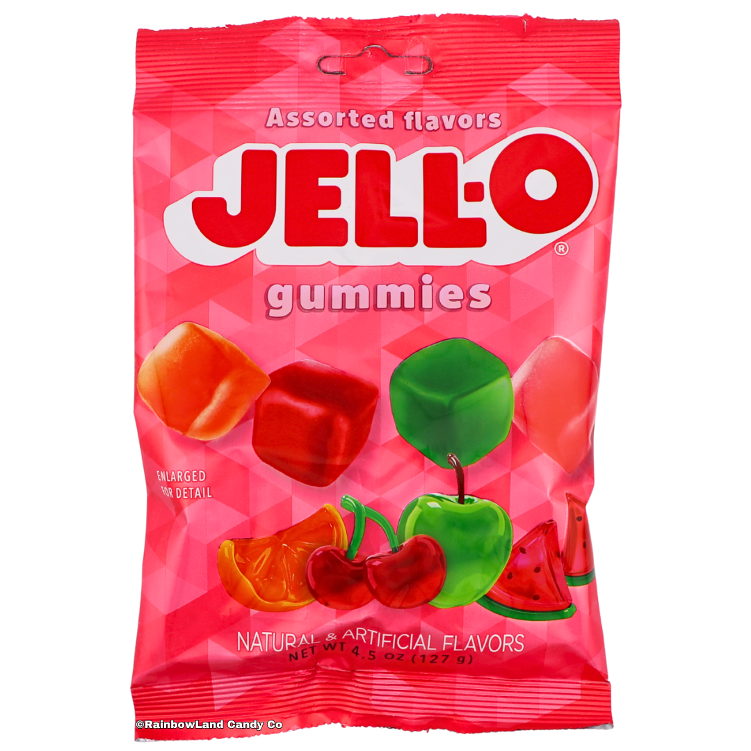 Jell-O Gummies Assorted Flavors bag front, pink and red packaging showing four gummy cube shapes (Green Apple, Watermelon, Cherry, Orange) alongside their real fruit images, net weight 4.5 oz.