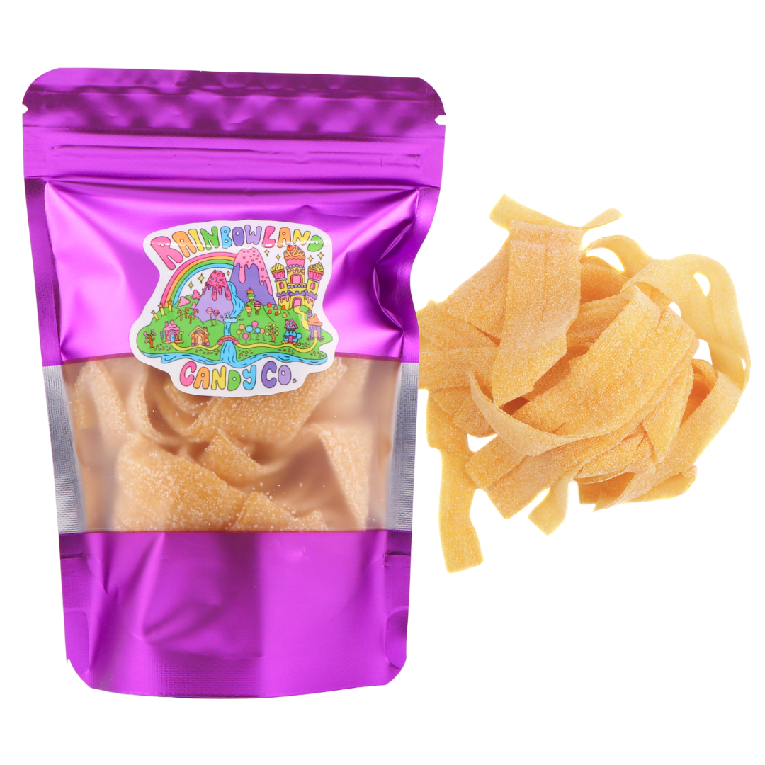 RainbowLand Candy Co. Mango Sour Belts in a purple metallic resealable stand-up pouch with a clear window, shown beside a loose pile of golden-orange, sugar-coated mango sour candy belts.