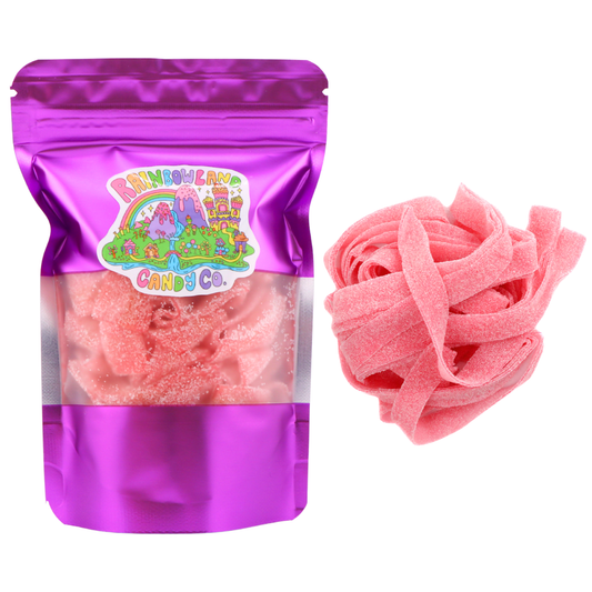 Purple resealable 3.6 oz RainbowLand Candy Co. bag of Pink Lemonade Sour Belts with a clear window showing pink sour sugar coated candy belts inside, displayed next to a pile of the candy belts.