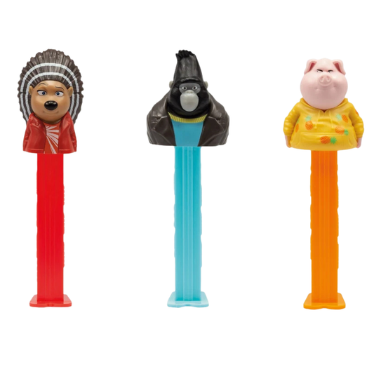 Three PEZ Sing 2 dispensers lined up together — Ash the hedgehog in red, Johnny the gorilla in light blue, and Gunter the pig in orange, each on a classic PEZ candy stem.