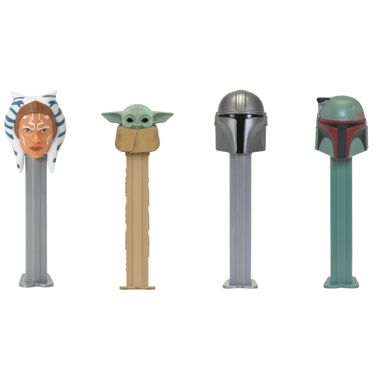 Four PEZ Star Wars Mandalorian dispensers lined up together — Ahsoka Tano with striped headtails, Grogu wrapped in a tan blanket, the Mandalorian in a silver beskar helmet, and Boba Fett in a green and red helmet.