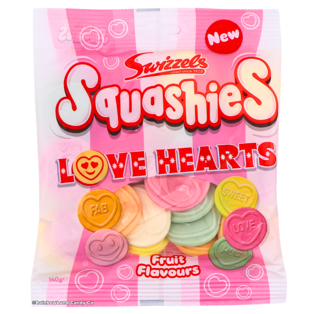 Pink striped 140g bag of Swizzels Squashies Love Hearts featuring soft, pillow-shaped heart candy pieces in Cherry, Pineapple, Lime, Orange, Blackcurrant, and Lemon flavors with sweet words and expressions on each piece, imported from the UK.
